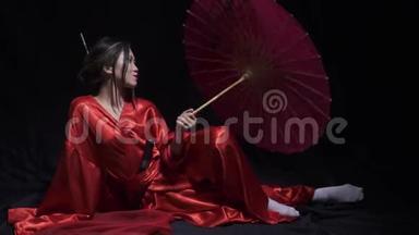 优雅的年轻女子穿着日本民族服装，<strong>玩转</strong>纸伞，微笑着